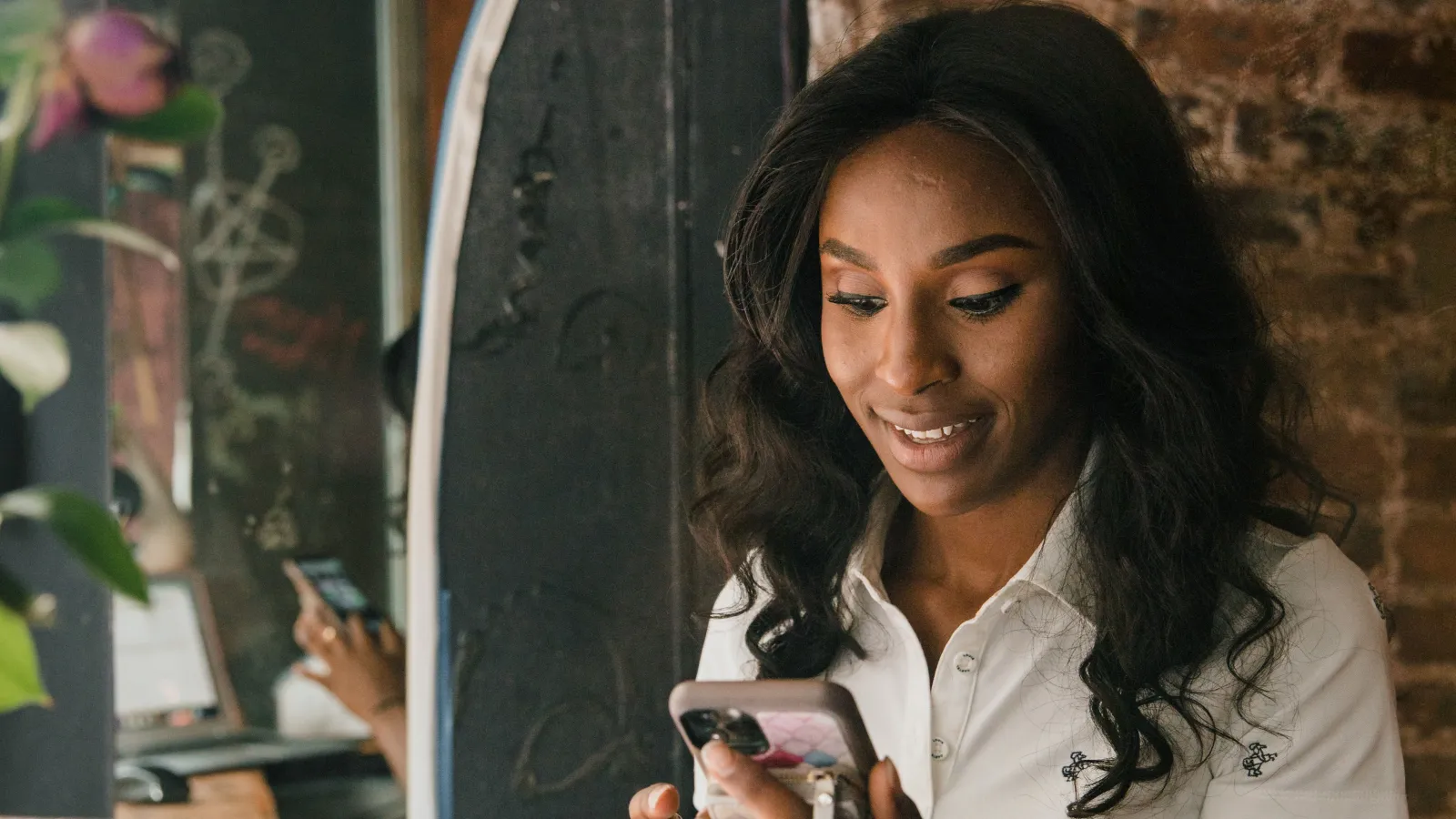 Photo: RDNE Stock project on Pexels A business owner smiling at her phone in a cafe